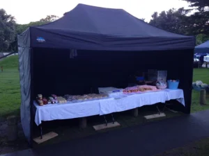 A black pop up gazebo with sides in an Auckland market