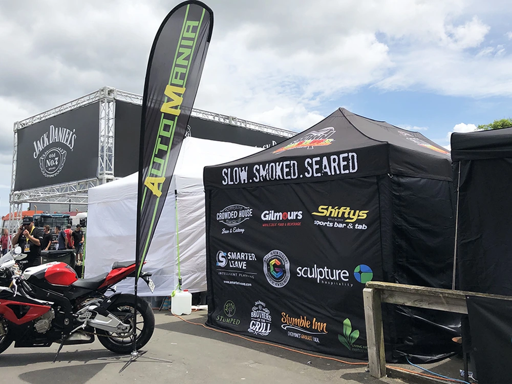a BBQ competition team promotes their sponsors on its black gazebo