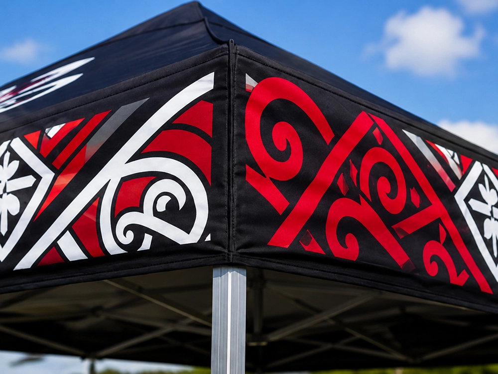 Close-up of a custom-printed gazebo canopy featuring Māori cultural design elements and iwi colours