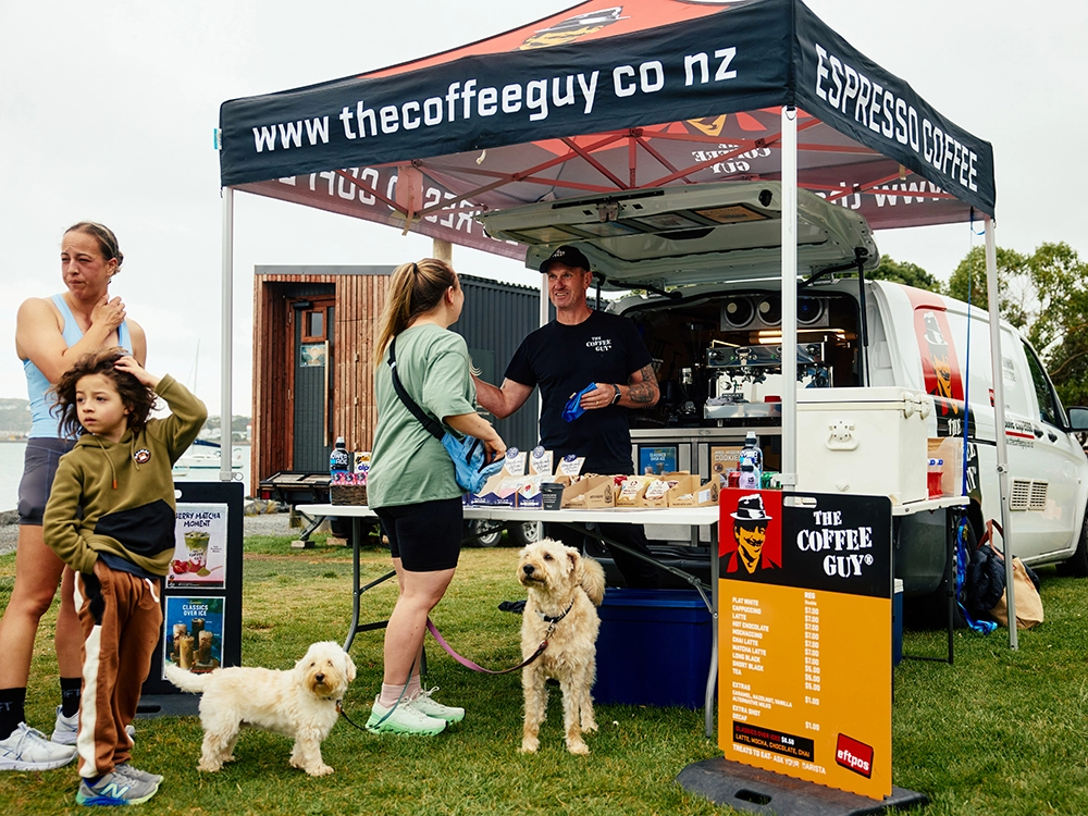 Coffee Guy Petone logoed Hercules gazebo standing out among vendor gazebos at a Wellington outdoor event